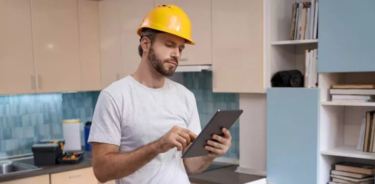 builder-helmet-working-with-tablet-kitchen-background