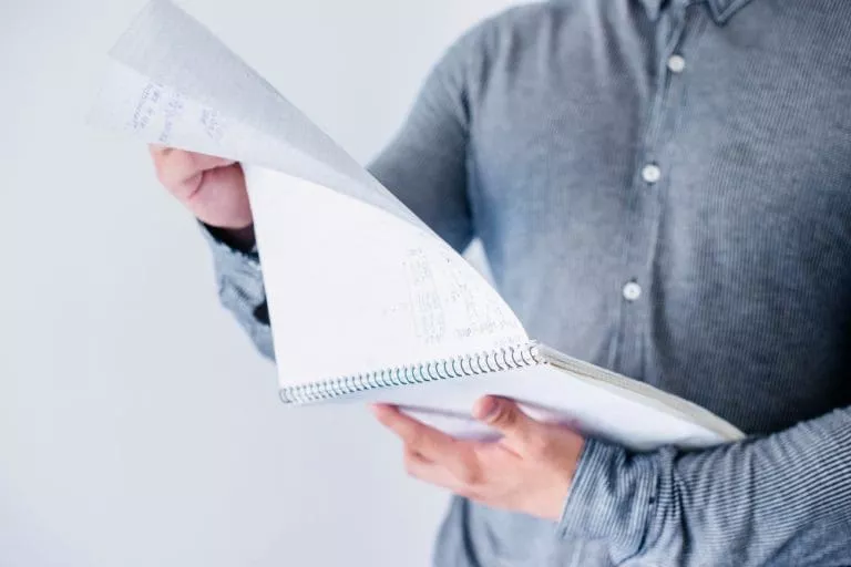 man-flipping-pages-notebook