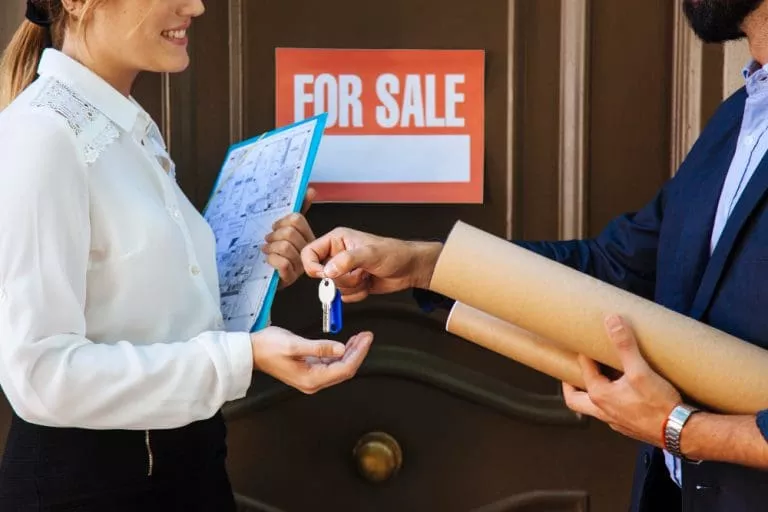 woman-receiving-key-from-real-estate-agent