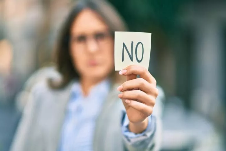 young-hispanic-businesswoman-with-serious-expression-holding-reminder-with-no-message-city