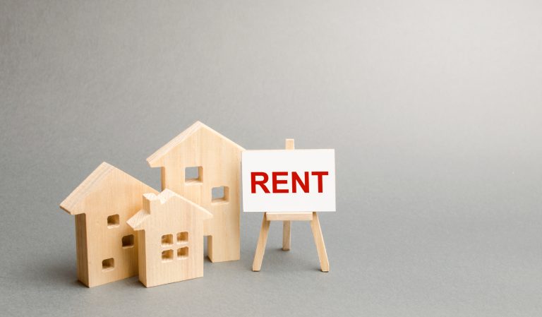 Three figures of houses and an easel with the word rent. The concept of temporary rental housing and real estate. Realtor services, search for optimal options. The choice between renting and buying