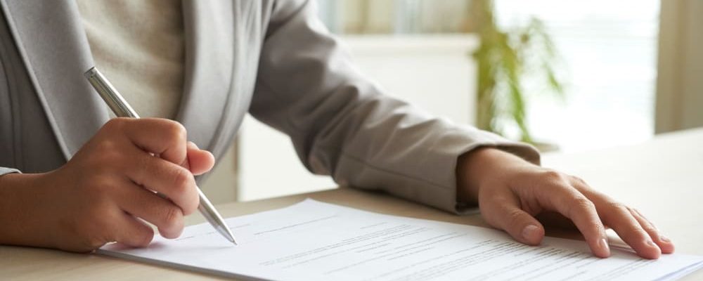 cropped-mid-section-unrecognizable-woman-signing-document