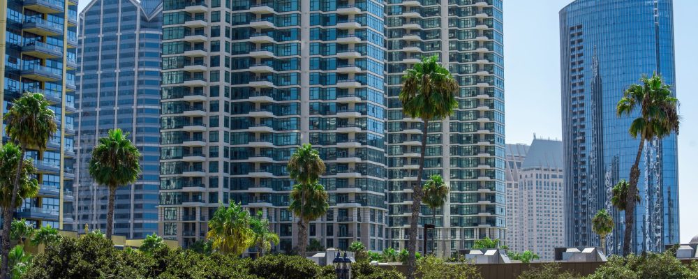 High apartment buildings with modern design, greenery on the foreground, sunny day in San Diego, USA