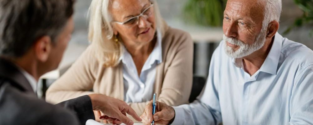 mature-couple-having-meeting-with-bank-manager-signing-lease-agreement-office-focus-is-mature-man